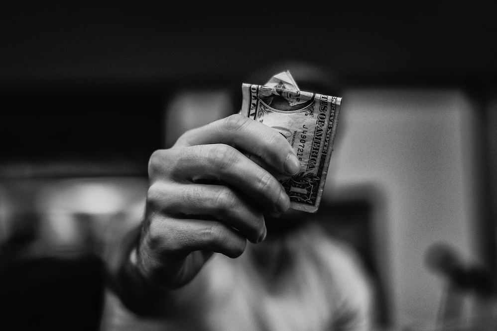 man holding a dollar bill black and white
