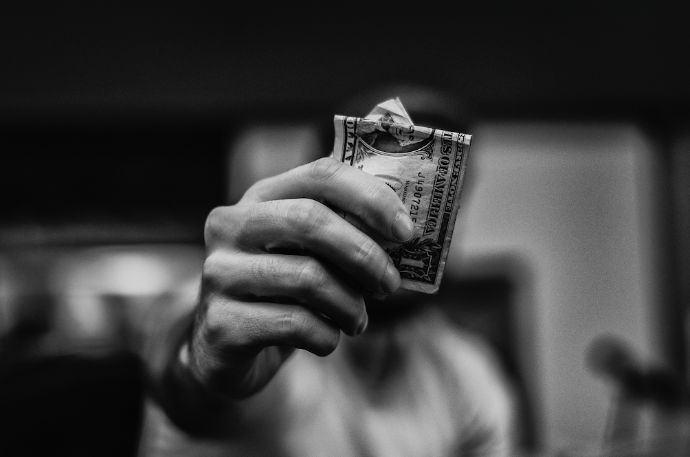 man holding a dollar bill black and white