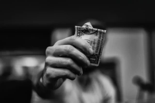 man holding a dollar bill black and white