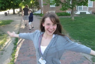 young girl smiling with her arms out