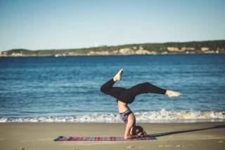 woman doing yoga on a beach